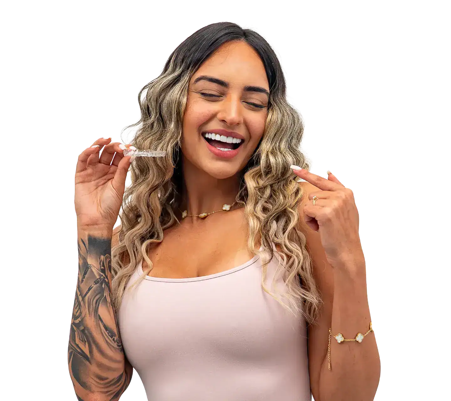 Happy woman with clear aligners, smiling and pointing at her teeth.