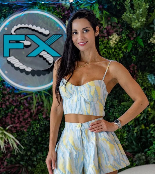 Smiling woman at FXBright orthodontic studio with logo in background.