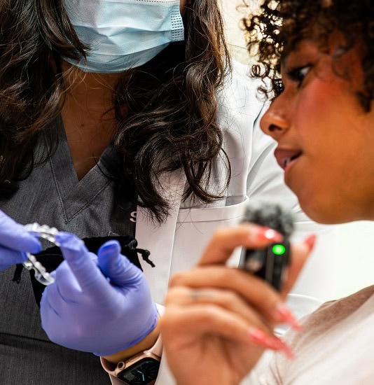 Dental professional examining patient's teeth with dental tools at SMILE-FX.