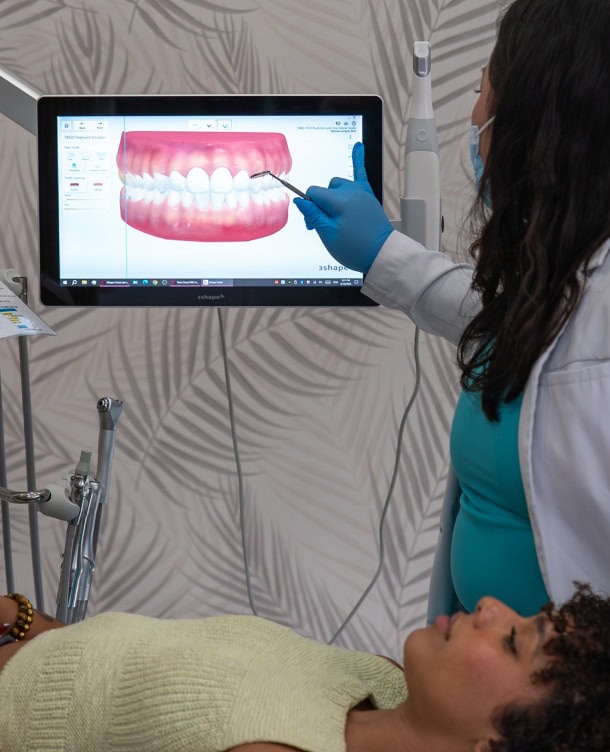 Dental professional analyzing digital teeth scan on monitor at SMILE-FX.